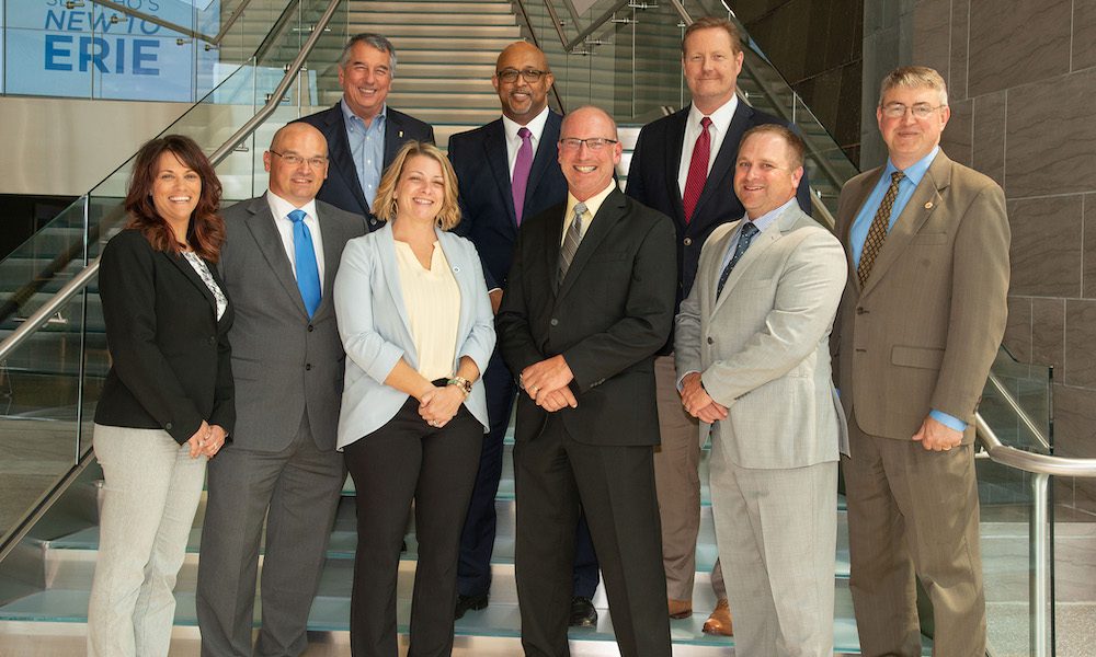 ERIE Insurance Names St. Marys Insurance Agency & Affiliates The #1 Company-Wide Agency For An Historic Second Year In A Row - St Marys and Erie Insurance members standing on steps smiling